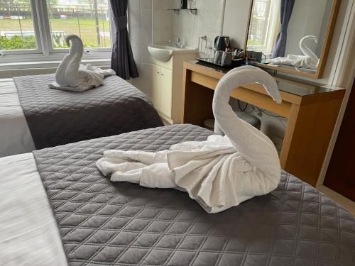 a bedroom with two swans towels on a bed at The Ashleigh in Paignton