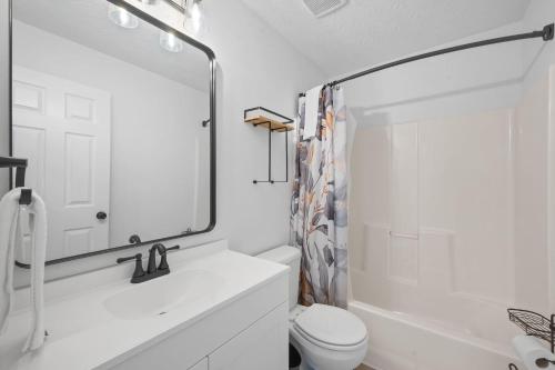 a bathroom with a sink and a toilet and a mirror at 4 apartments 10 bedrooms - 2 and a half Miles from Ark in Williamstown