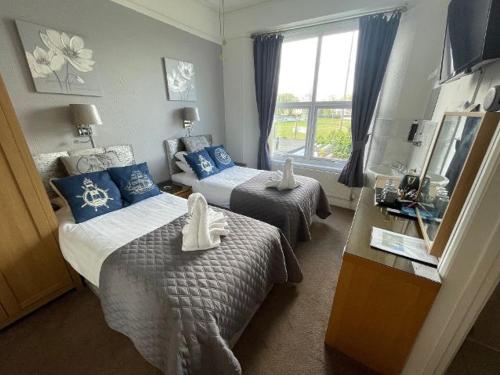 a hotel room with two beds and a window at The Ashleigh in Paignton
