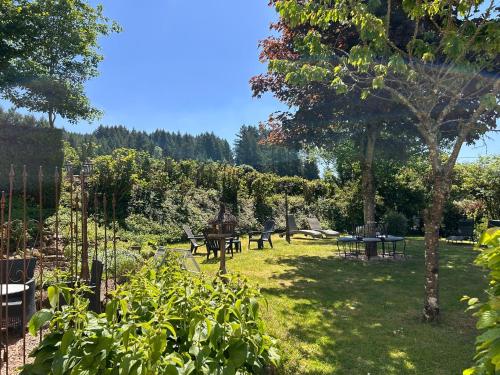a garden with benches and tables in the grass at Auberge de La Chaloire in La Petite-Verrière