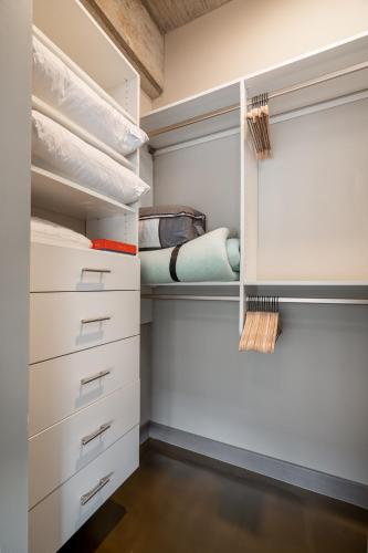 a walk in closet with white cabinets and drawers at Sable 404 - Alcove in Minneapolis