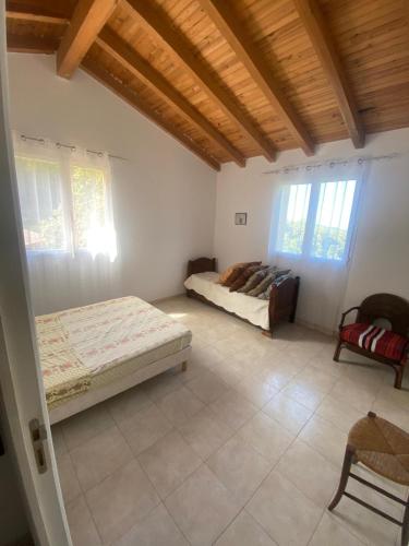 une chambre avec deux lits dans une pièce avec fenêtres dans l'établissement Maison individuelle, à Olivese