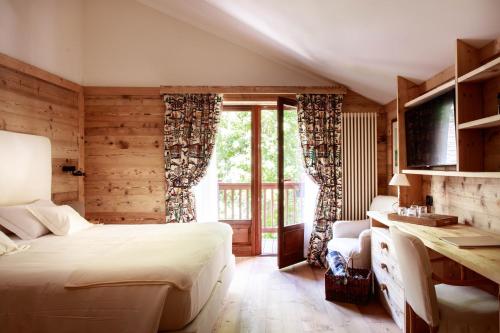 a bedroom with a bed and a large window at Auberge de La Maison in Courmayeur