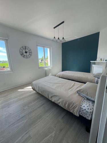 - une chambre avec 2 lits et une horloge murale dans l'établissement Charmante maison à Lagord avec jardin privatif, à Lagord