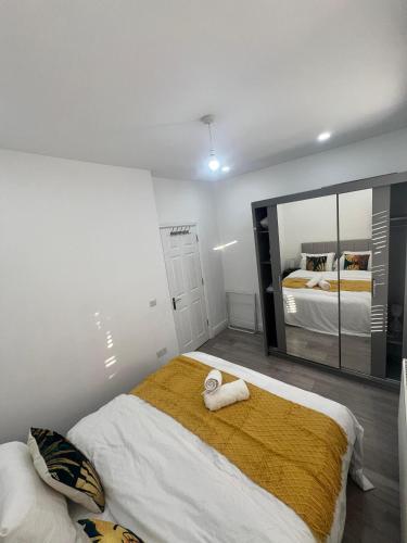 a bedroom with a bed and a large mirror at Ilford, Luxury Flat 3 close to station in Ilford
