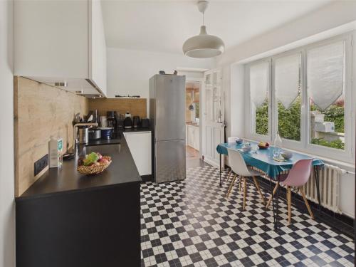 une cuisine avec une table et des chaises dans une pièce dans l'établissement 350m de la plage- meublé 4 étoiles pour 8 avec jardin, à l'Île-Tudy