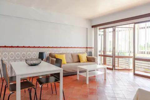 a living room with a couch and a table at Casa na Praia in Sesimbra