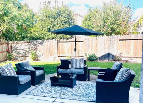 a patio with four chairs and an umbrella at Huge Home near Old Folsom Pet & Family Friendly in Folsom