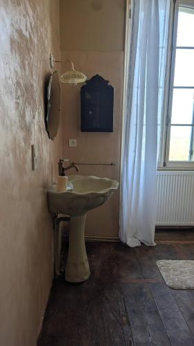 une salle de bain avec un lavabo et une fenêtre dans l'établissement Maison Nathis, à Saint-Sulpice-de-Roumagnac