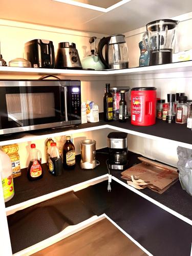 a kitchen pantry with a microwave and various items on shelves at Huge Home near Old Folsom Pet & Family Friendly in Folsom