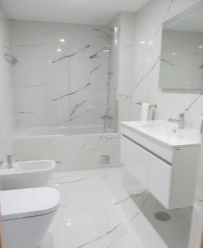 a white bathroom with a shower and a toilet and a sink at Oporto Yellow Apartments in Porto