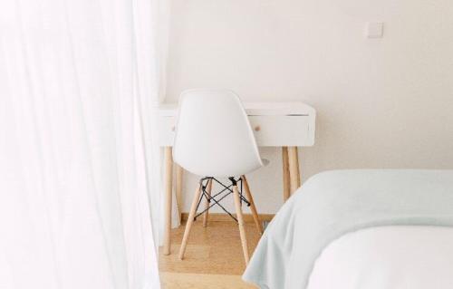 a white bedroom with a chair and a bed at Oporto Yellow Apartments in Porto