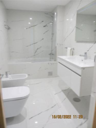a white bathroom with a shower and a toilet and sink at Oporto Yellow Apartments in Porto
