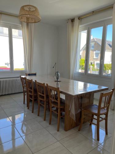 une salle à manger avec une grande table et des chaises en bois dans l'établissement Maison Bengali, à Granville