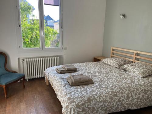 une chambre avec un lit, une chaise et une fenêtre dans l'établissement Maison Bengali, à Granville