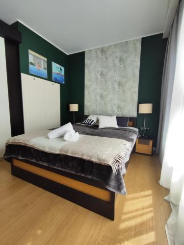 a bedroom with a large bed with green walls at Visit Poznan in Dąbrówka