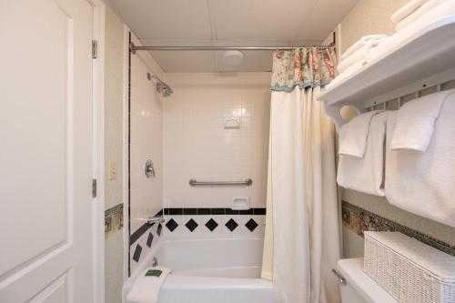 a bathroom with a white tub and a shower at Boardwalk Plaza Hotel in Rehoboth Beach