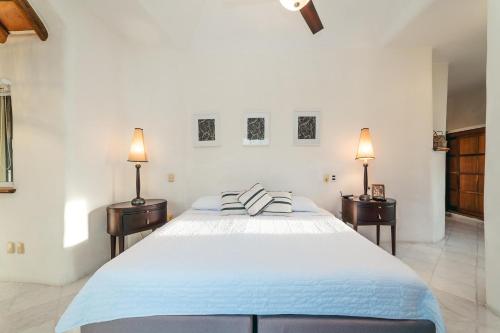 a white bedroom with a large bed and two night stands at 2026 - Sueno Real D2 in Santa Cruz Huatulco