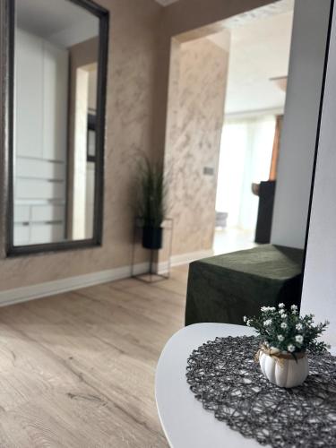 a living room with a table and a mirror at RIN SkyLounge Apartment in Cluj-Napoca