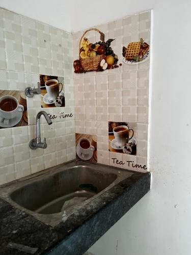 a kitchen with a sink with pictures on the wall at Nandankanan Motel in Bārang