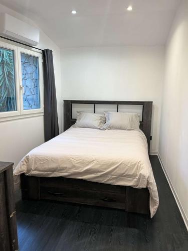 - une chambre dotée d'un grand lit avec des draps blancs et une fenêtre dans l'établissement Le Moulin des Sens - Grasse, à Grasse