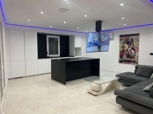 un salon avec une télévision, un canapé et une table dans l'établissement Le Moulin des Sens - Grasse, à Grasse