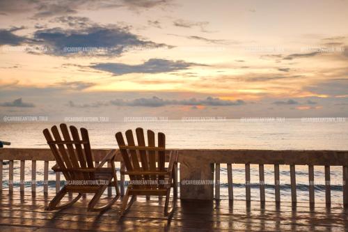 two chairs and a table on the beach with the ocean at Caribbean Town Tolu in Tolú