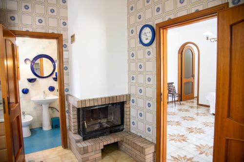 a living room with a fireplace and a clock on the wall at Villa Ada in Leporano Marina