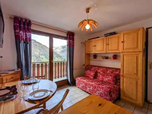 un salon avec un canapé rouge et une table dans l'établissement Appartement 6 personnes au pied des pistes, à Saint-Jean-dʼAulps