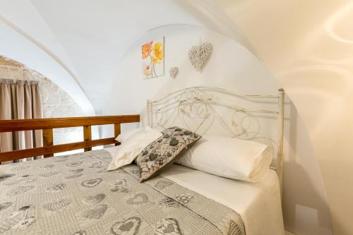 a bedroom with a bed with a white headboard at Pizzicarella by Palazzo Refolo in Martano