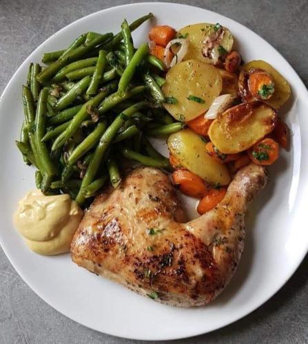 a plate of food with a chicken and vegetables at Hilltop Getaway Grill in Kihingo