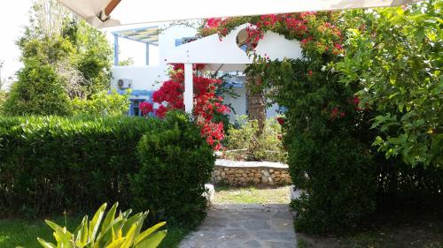 a garden with flowers and a bench in the middle at Panorama Paros in Parikia