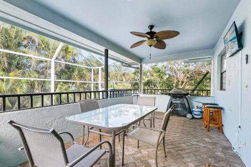 a dining room with a table and chairs on a balcony at Walk to the Beach & Everywhere! Private Pool! in Henry Key