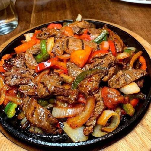 a plate of food with meat and vegetables on a table at Hilltop Getaway Grill in Kihingo