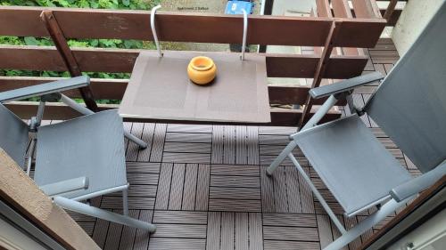 an orange vase sitting on a patio with two chairs at Vlotho Apartment 2 in Vlotho