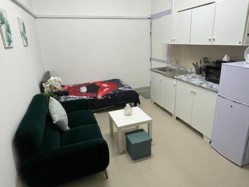 a living room with a couch and a table and a kitchen at Fully furnished studio in Abu Dhabi