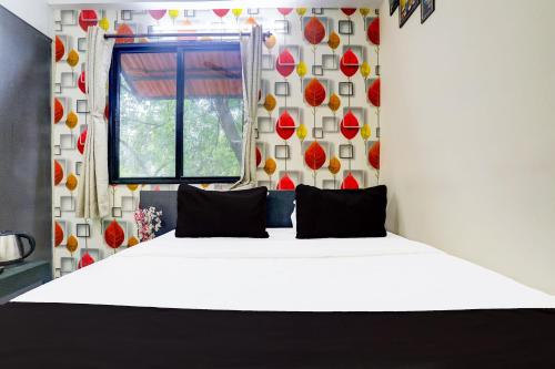 a bedroom with a large white bed with a window at Super Hotel O Sunshine Palace in Nagpur