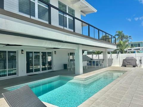 a house with a swimming pool in front of a house at Bayside Grande Villa in Clearwater Beach
