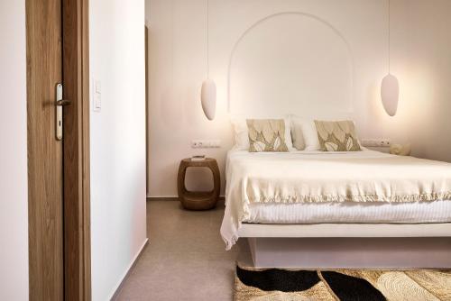 a white bedroom with a white bed and a mirror at Dash Milos in Tripití