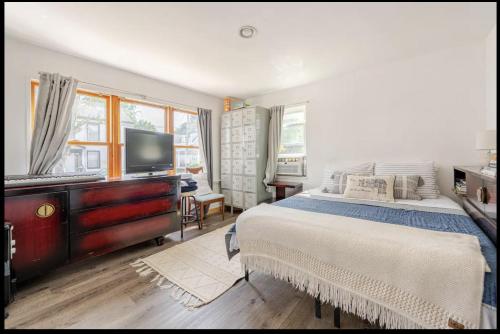 a bedroom with a bed with a dresser and a television at 2 bedroom Apt in Kingston