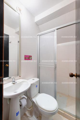 a bathroom with a toilet and a sink and a shower at Caribbean Town Tolu in Tolú
