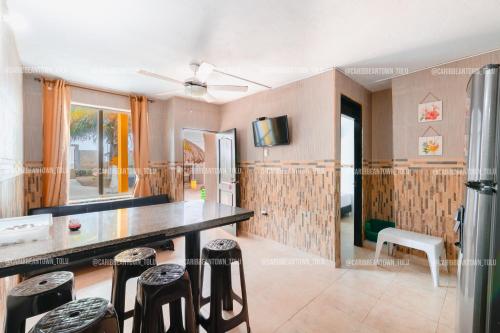 a kitchen with a table and stools at Caribbean Town Tolu in Tolú
