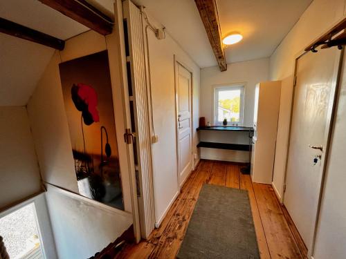 a hallway with a door to a room with a sink at Rosengården - Viby B&Bi in Vretstorp