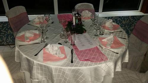 a table with a white table cloth and pink napkins at Sokoterme Hotel in Soko Banja