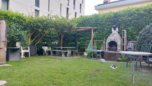 a garden with a grill and a table and chairs at Casa celeste, stanza in appartamento condiviso in Minusio