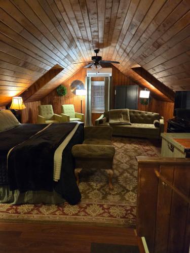 a bedroom with a large bed and a couch and chair at The Culpepper Inn in Elizabeth City