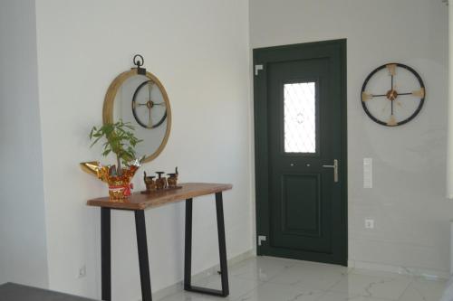 a room with a green door and a table with a mirror at Issos House in Agios Georgios