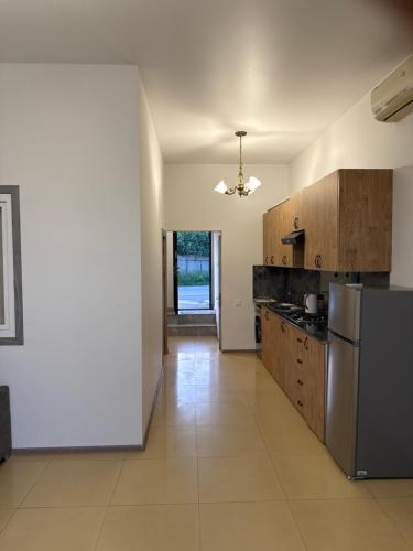 a kitchen with wooden cabinets and a stainless steel refrigerator at Home in Pʼarakʼar