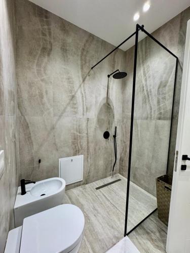 a bathroom with a shower and a toilet in it at TIS, Green Coast in Palasë