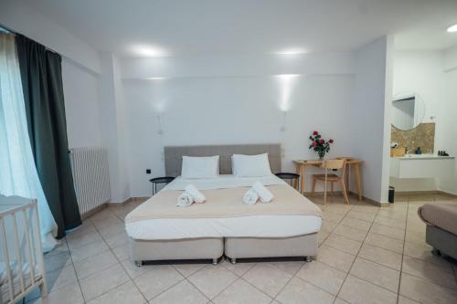 a bedroom with a large bed with towels on it at Thirsty Dog Urban Port Studios in Igoumenitsa